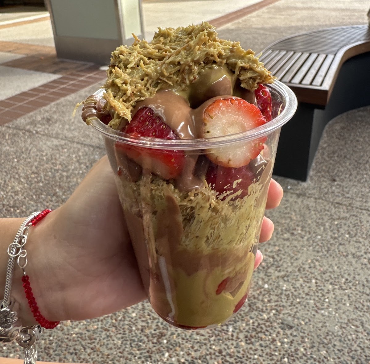 A cup of strawberries, chocolate soft serve and pistachio crumble held up in Harbour Town